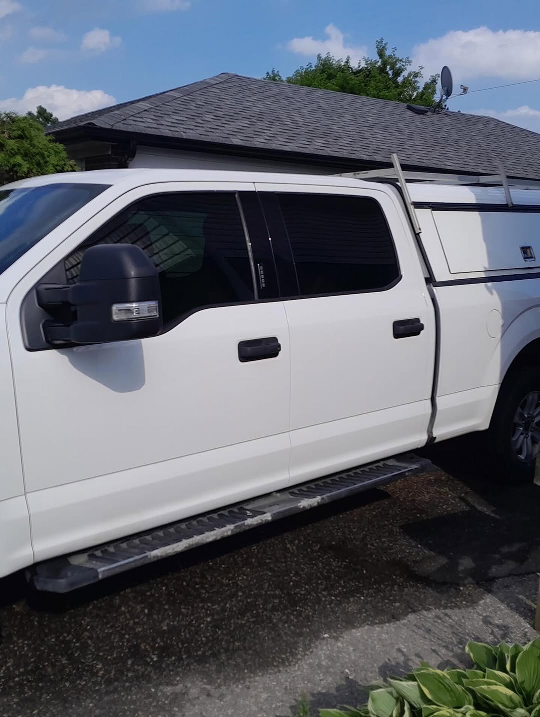 White F-150 side profile with ladder rack and LEER canopy